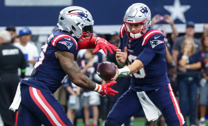 New England Patriots quarterback Mac Jones (10) and running back Ezekiel Elliott (15) warm up before the game against the Dallas Cowboys at AT&T Stadium.